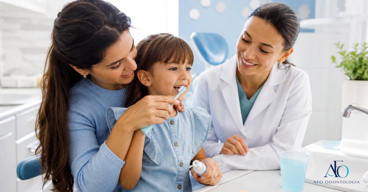 Crianca escovando os dentes com orientacao sobre acucar e pasta com fluor